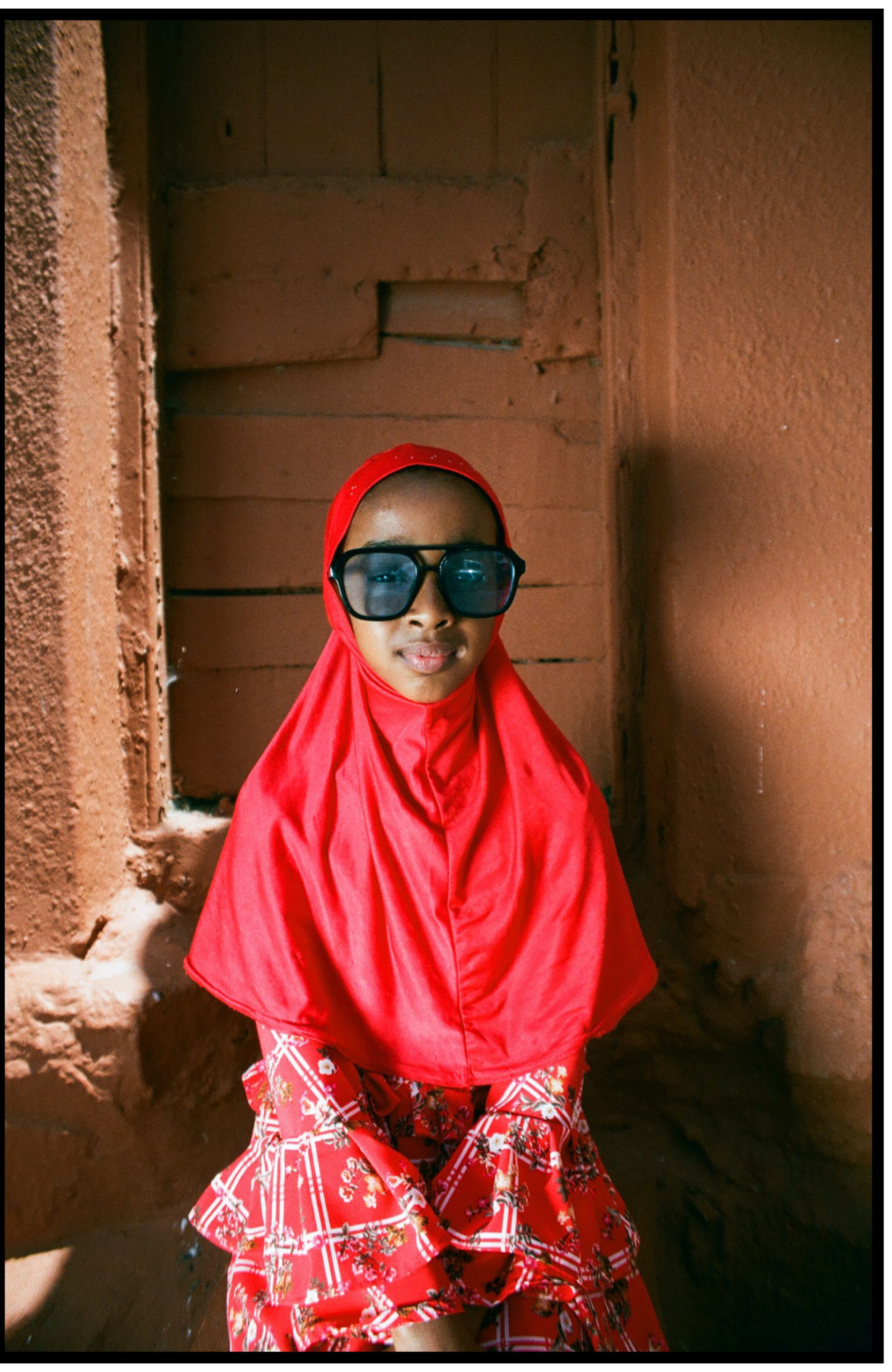 Heaven Lies At Thy Mothers Feet bu Faatimah Allie and Ya’eesh Dollie 2 Hijabi child in red with retro sunglasses with blue lenses